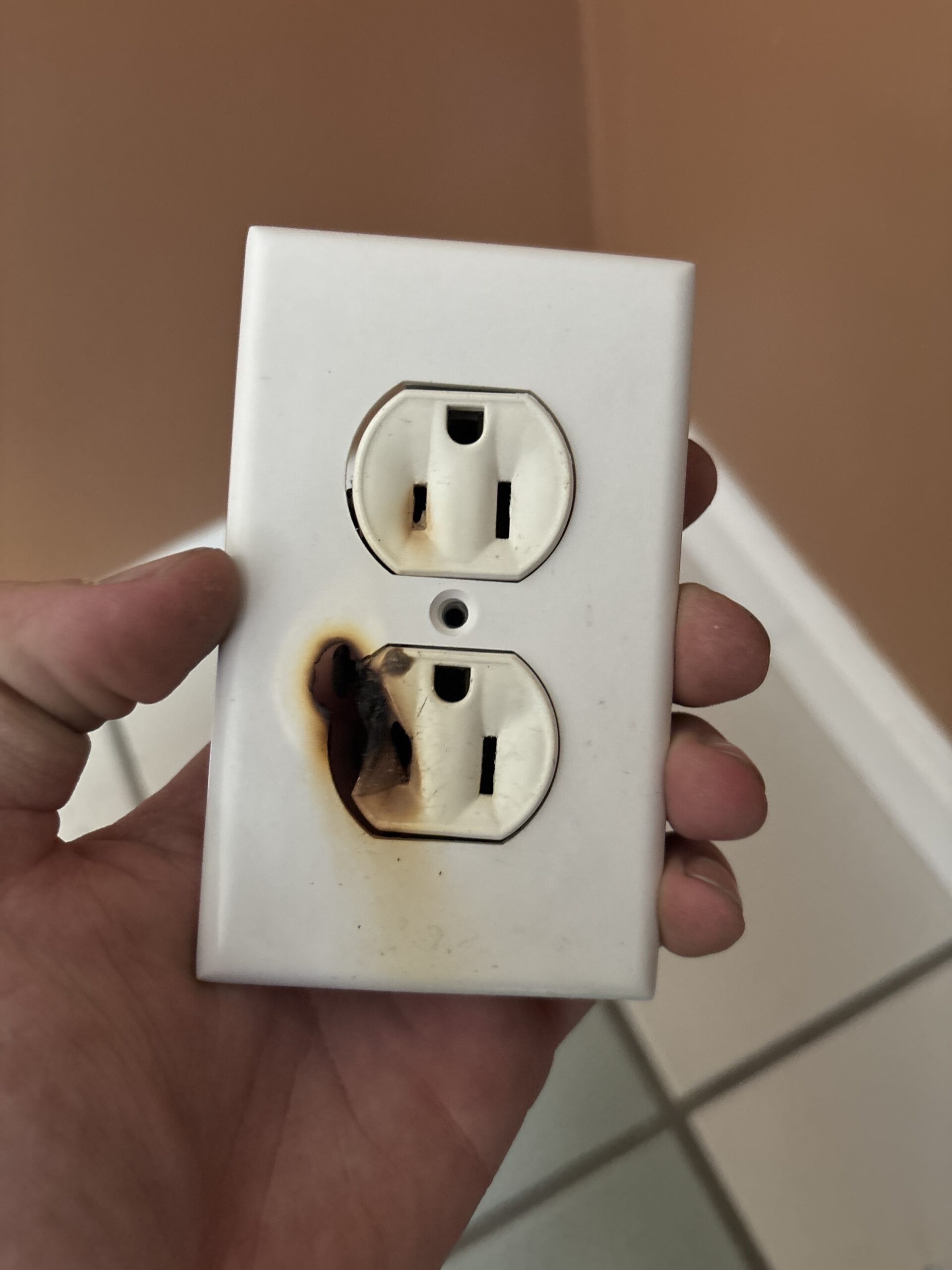 Burned electrical outlet discovered during a residential service call in Maine